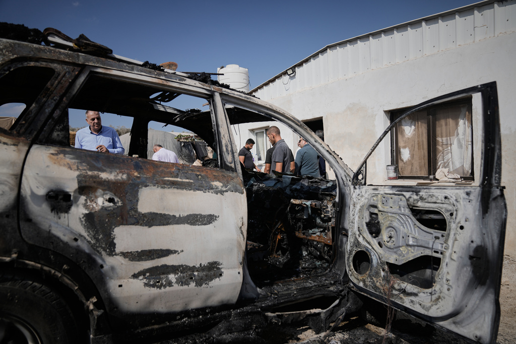 Palestinians survey damage in an industrial zone following an attack by Israeli settlers the previous day in the West Bank village of Beit Lid, near Tulkarm, Wednesday, Nov. 12, 2025. (AP Photo/Majdi Mohammed)