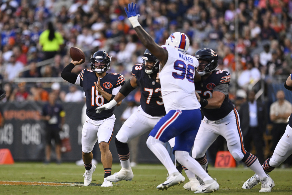 Chicago Bears quarterback Caleb Williams (18) throws a pass under pressure from Buffalo Bills defensive tackle Deone Walker (96) in the first half of a preseason NFL football game Sunday, Aug. 17, 2025, in Chicago. (AP Photo/Paul Beaty)