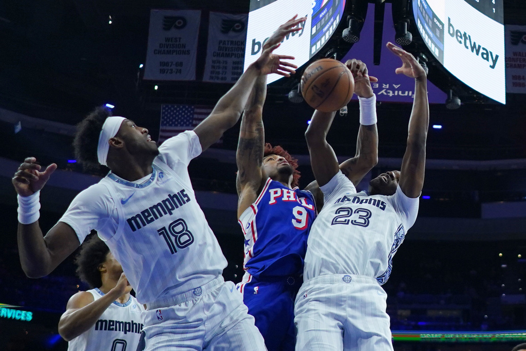 Philadelphia 76ers' Kelly Oubre Jr. (9), Memphis Grizzlies' Olivier-Maxence Prosper (18) and Cedric Coward battle for the ball during the first half of an NBA basketball game, Tuesday, March 10, 2026, in Philadelphia. (AP Photo/Matt Rourke)