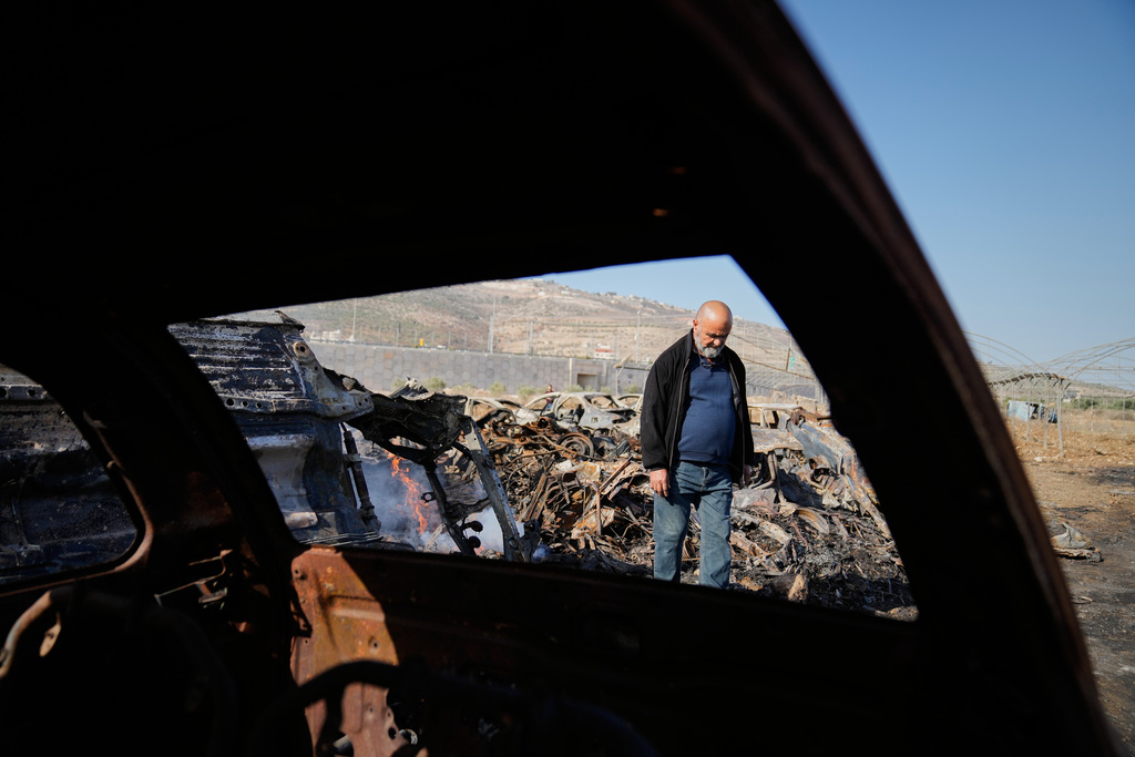Mohammad Dalal looks at scorched cars in his scrapyard that was set ablaze the night before by who local residents alleged were Israeli settlers in the town of Huwara near the West Bank city of Nablus, Friday, Nov. 21, 2025. (AP Photo/Nasser Nasser)