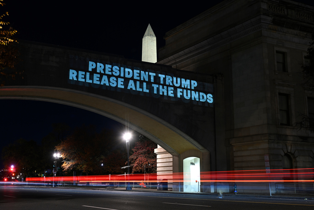 A message from the National Women's Law Center concerning the announcement by the Trump administration of restoring only half funding the SNAP benefits is projected on the U.S. Department of Agriculture building, Monday, Nov. 3, 2025, in Washington. (AP Photo/John McDonnell)