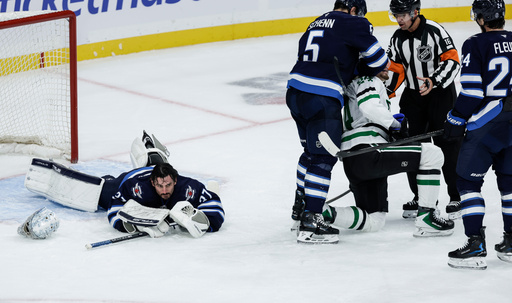 Winnipeg Jets' Luke Schenn (5) roughs up Dallas Stars' Roope Hintz (24) after Hintz fell on Jets' goaltender Connor Hellebuyck (37) during second-period NHL hockey game action in Winnipeg, Manitoba, Thursday, Oct. 9, 2025. (John Woods/The Canadian Press via AP) Winnipeg Jets' Luke Schenn (5) roughs up Dallas Stars' Roope Hintz (24) after Hintz fell on Jets' goaltender Connor Hellebuyck (37) during second-period NHL hockey game action in Winnipeg, Manitoba, Thursday, Oct. 9, 2025. (John Woods/The Canadian Press via AP)