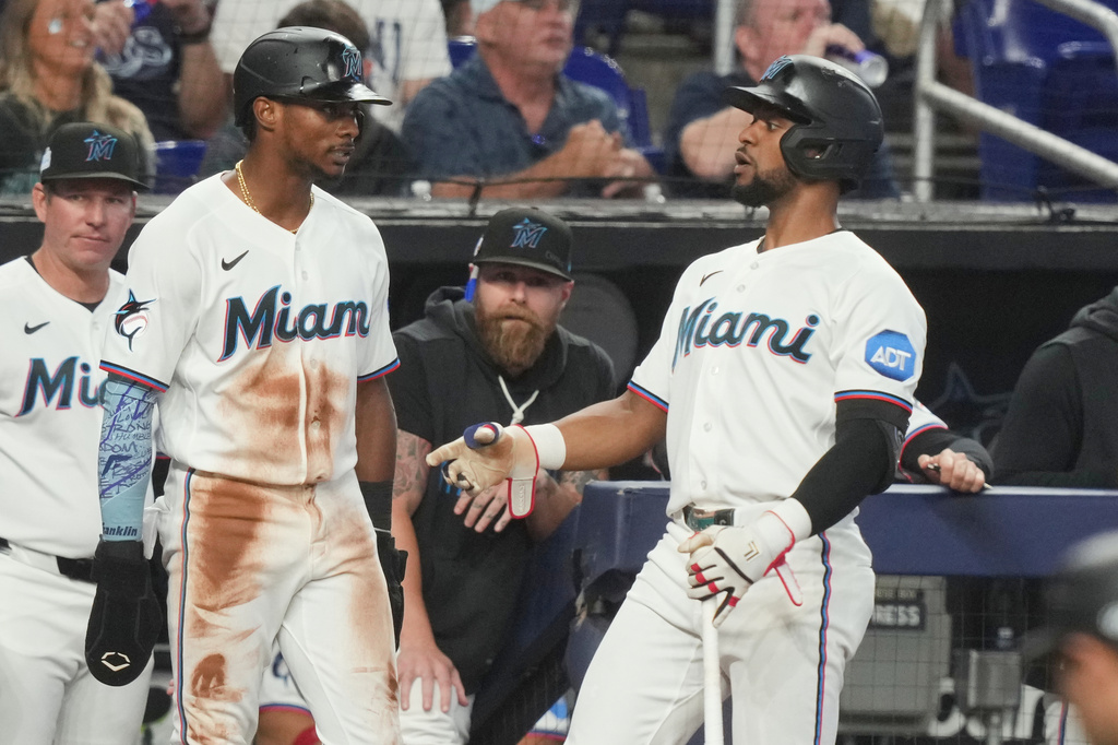 Miami Marlins' Esteury Ruiz, talks to Otto Lopez after scoring on a hit by Joe Mack during the fifth inning of a baseball game against the Tampa Bay Rays Saturday, June 6, 2026, in Miami. (AP Photo/Marta Lavandier)