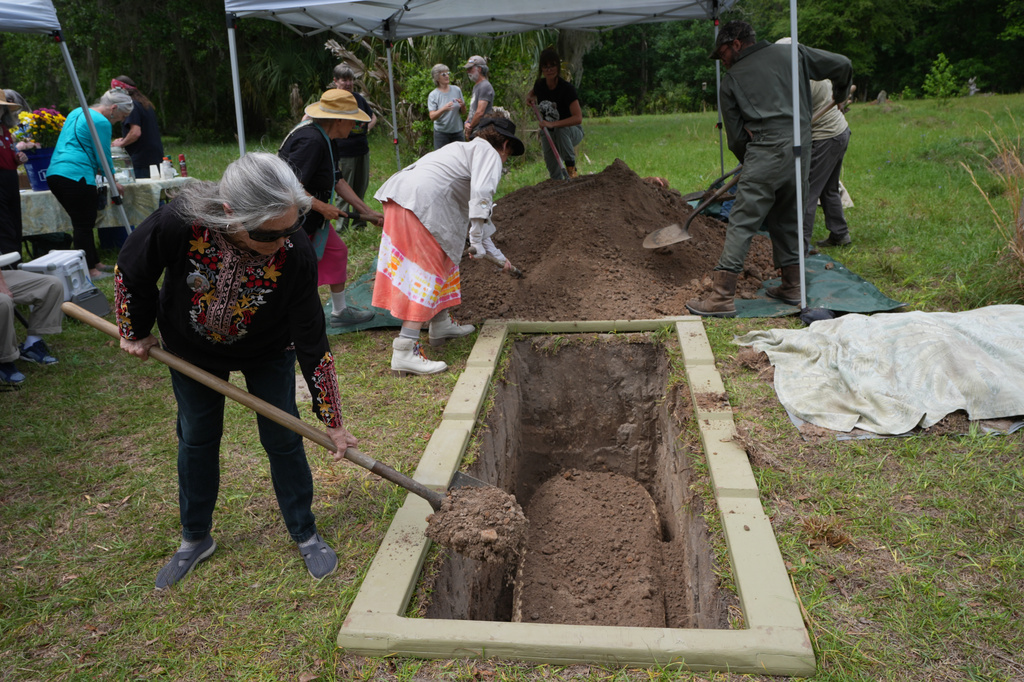 Friends and family help bury the body of Jacqueline Betz at the Prairie Creek Conservation Cemetery, Monday, April 6, 2026, in Gainesville, Fla. (AP Photo/Marta Lavandier)