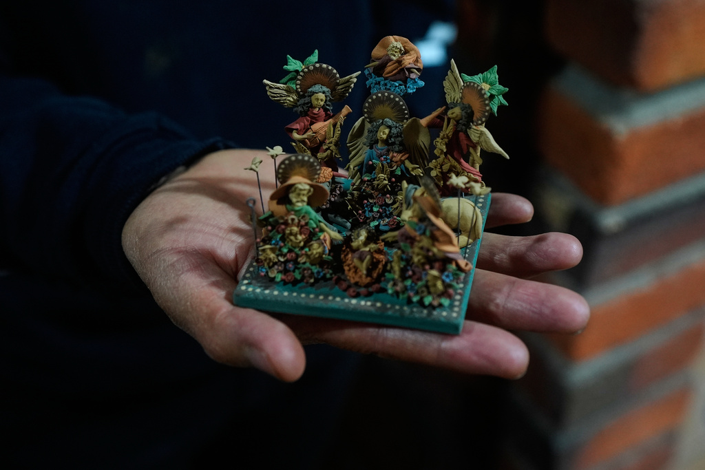 Mexican craftsman Cecilio Sanchez shows one of his miniature clay pieces at his atelier in Metepec, Mexico, Thursday, Oct. 9, 2025. (AP Photo/Fernando Llano)