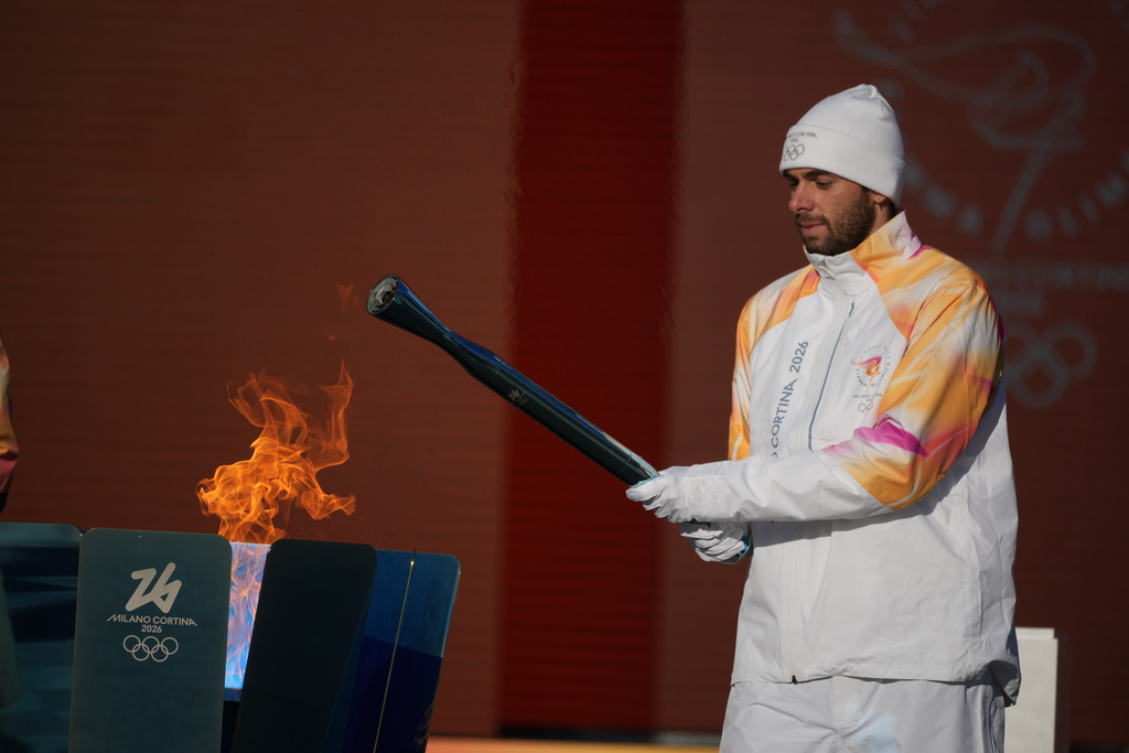 Italian swimmer Gregorio Paltrinieri lights the 2026 Milan Cortina Winter Olympics torch in Rome as it begins its journey through Italy, Saturday, Dec. 6, 2025, a journey that will conclude in Milan in February 2026. (AP Photo/Andrew Medichini)