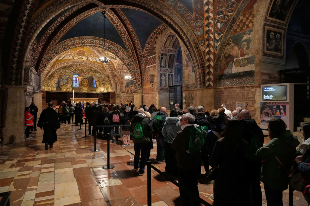 Pilgrims honor the bones of St. Francis during the first public display inside the St. Francis Basilica, marking the 800th anniversary of the saint death, in Assisi, Italy, Sunday, Feb. 22, 2026.(AP Photo/Gregorio Borgia)