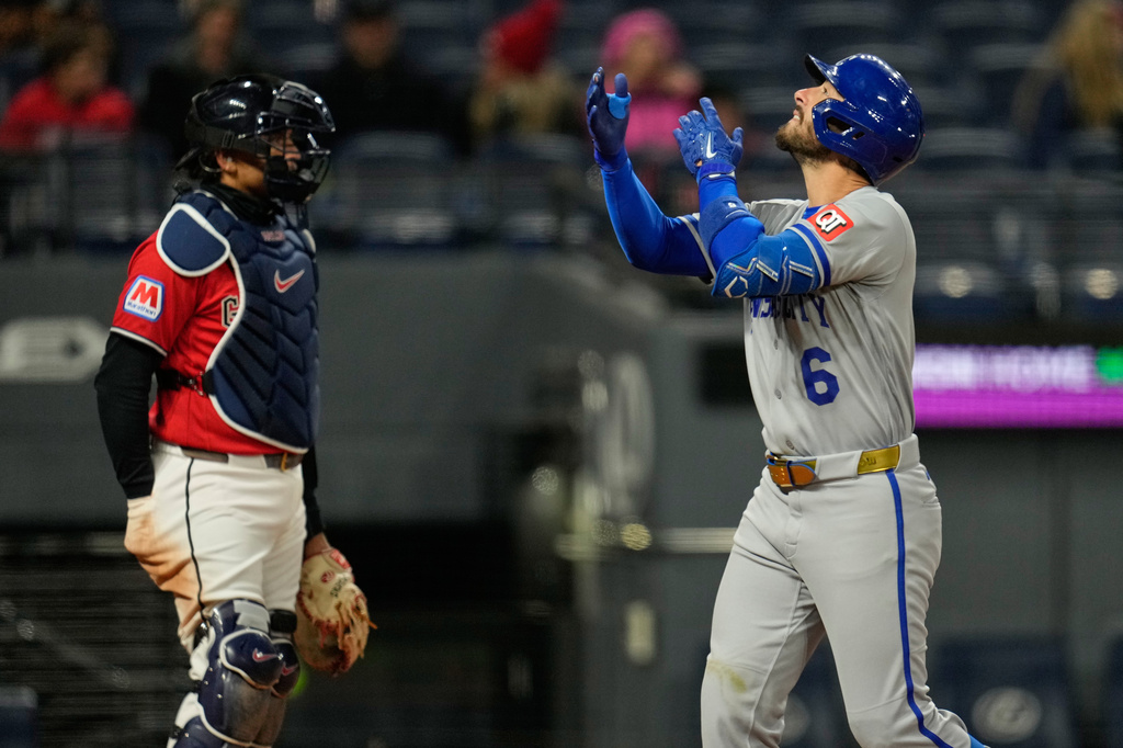 Kansas City Royals' Jonathan India gestures in front of Cleveland Guardians catcher Bo Naylor, left, as he crosses the plate with a two-run home run in the eighth inning of a baseball game against the Cleveland Guardians in Cleveland, Monday, April 6, 2026. (AP Photo/Sue Ogrocki)