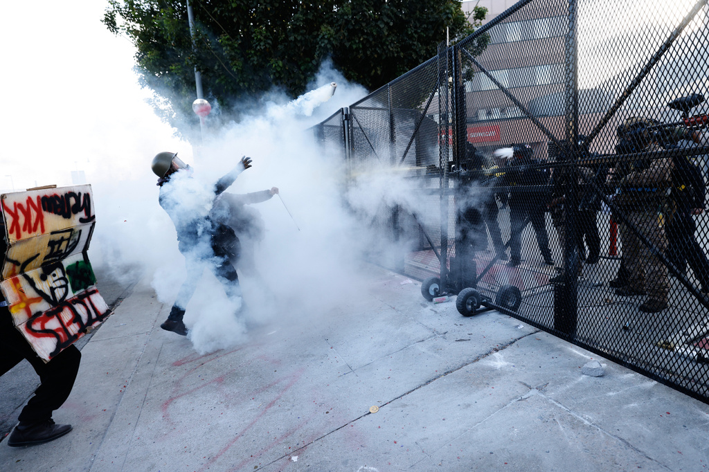 Protesters face off against police firing tear gas outside the Metropolitan Detention Center in downtown Los Angeles during a "No Kings" rally Saturday, March 28, 2026. (AP Photo/Jill Connelly)