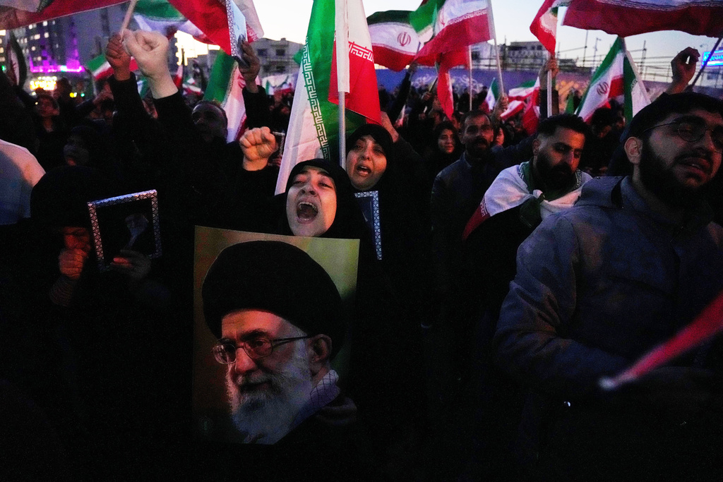 Government supporters chant slogans as they gather in mourning after state TV officially announced the death of Iranian Supreme Leader Ayatollah Ali Khamenei, shown in the poster, in Tehran, Iran, Sunday, March 1, 2026. (AP Photo/Vahid Salemi)