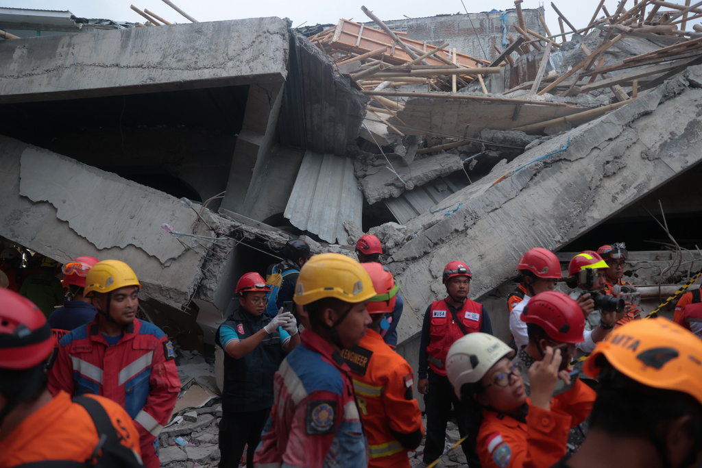 Rescuers search for victims at the site where a building under construction collapsed at an Islamic boarding school in Sidoarjo, East Java, Indonesia, Tuesday, Sept. 30, 2025. (AP Photo/Trisnadi)