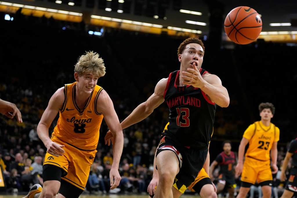 Maryland forward Elijah Saunders (13) runs down a loose ball ahead of Iowa forward Cooper Koch (8) during the first half of an NCAA college basketball game, Saturday, Dec. 6, 2025, in Iowa City, Iowa. (AP Photo/Charlie Neibergall)