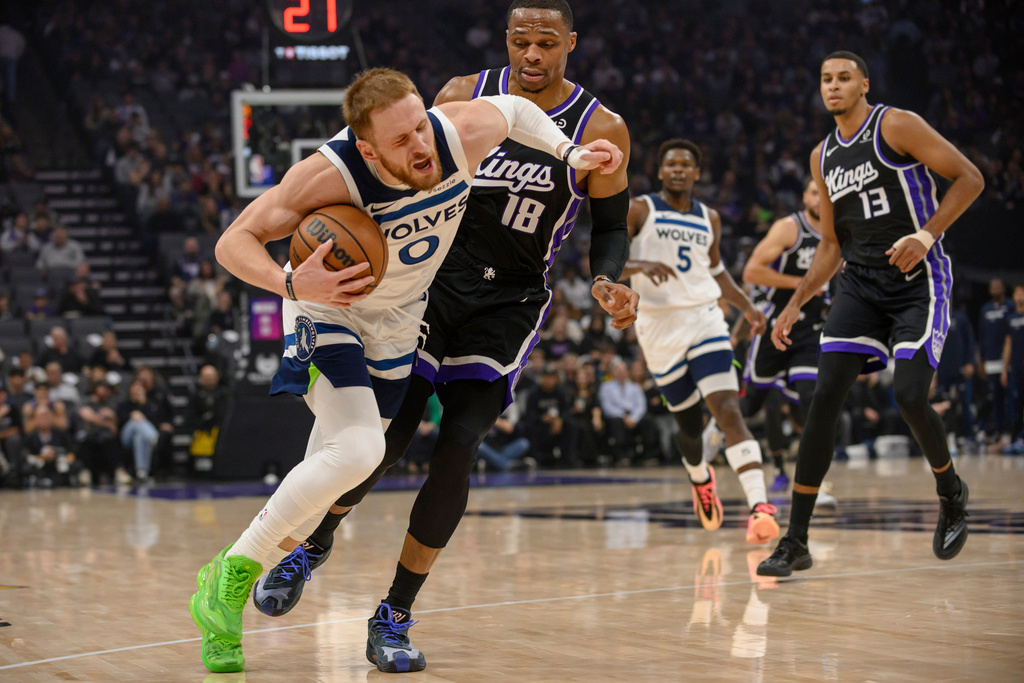 Minnesota Timberwolves guard Donte DiVincenzo (0) is guarded by Sacramento Kings guard Russell Westbrook (18) during the first half of an NBA basketball game in Sacramento, Calif., Monday, Nov. 24, 2025. (AP Photo/Randall Benton)