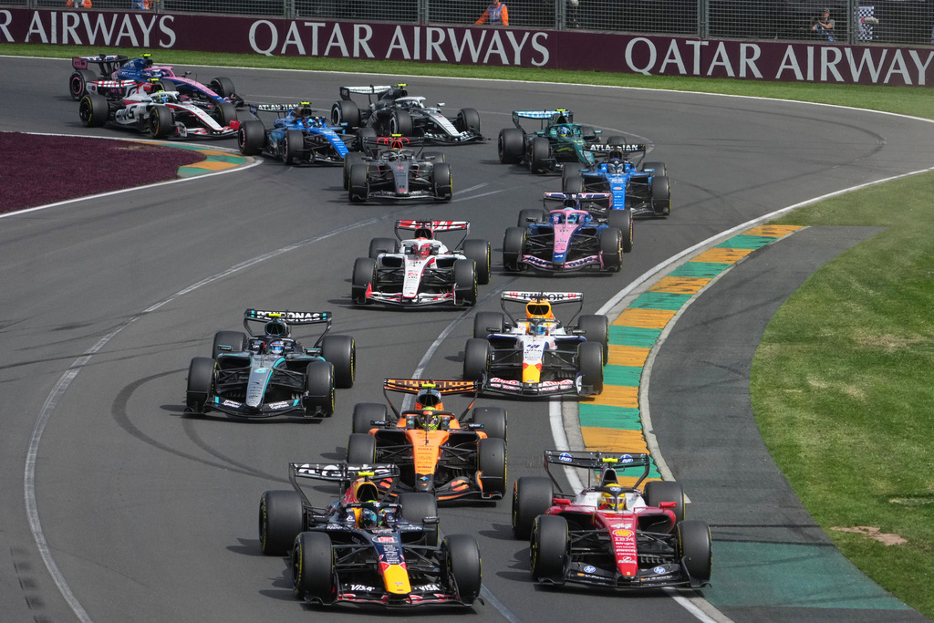 Red Bull driver Isack Hadjar, left, of France and Ferrari driver Lewis Hamilton of Britain steer their cars out of turn two at the start of the Australian Formula One Grand Prix at Albert Park, in Melbourne, Australia, Sunday, March 8, 2026. (AP Photo/Asanka Brendon Ratnayake)