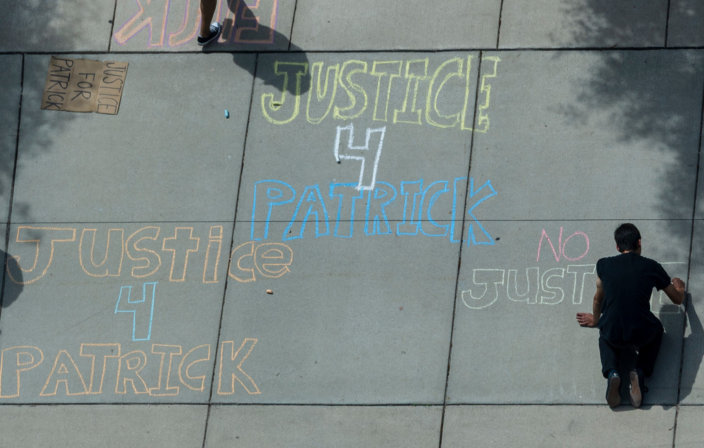 FILE - Patrick Lyoya supporters write messages on the sidewalk with chalk outside the Kent County Courthouse in Grand Rapids, Mich., May 7, 2025. (Joel Bissell/Kalamazoo Gazette via AP, File)