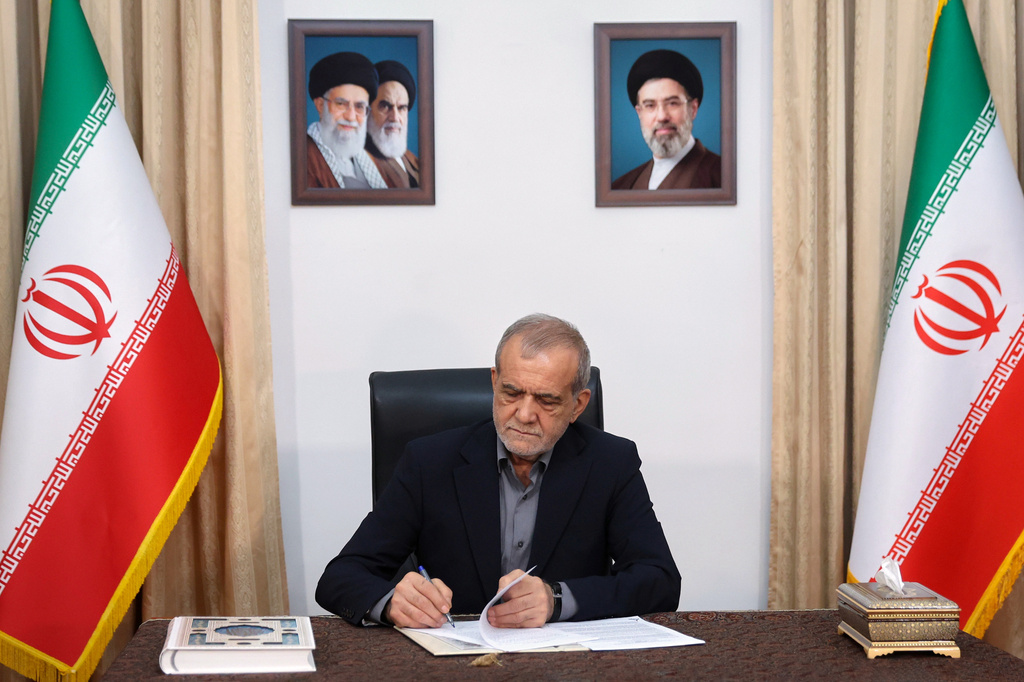 In this photo realised by Iran Presidentcy Office, Iranian President Masoud Pezeshkian signs a memorandum of understanding already signed by U.S. President Donald Trump aimed at ending the war and launching negotiations on a broader agreement, in Tehran, Iran, early Thursday, June 18, 2026. (Iranian Presidency Office via AP)