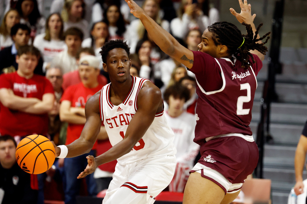 North Carolina State's Musa Sagnia, left, passes the ball around Texas Southern's Troy Hupstead (2) during the first half of an NCAA college basketball game in Raleigh, N.C., Wednesday, Dec. 17, 2025. (AP Photo/Karl DeBlaker)
