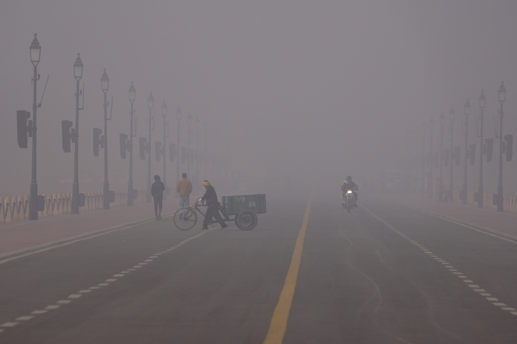 A man pushes a cycle cart in a smog-covered morning in New Delhi, India, Monday, Dec. 15, 2025. (AP Photo/Piyush Nagpal)