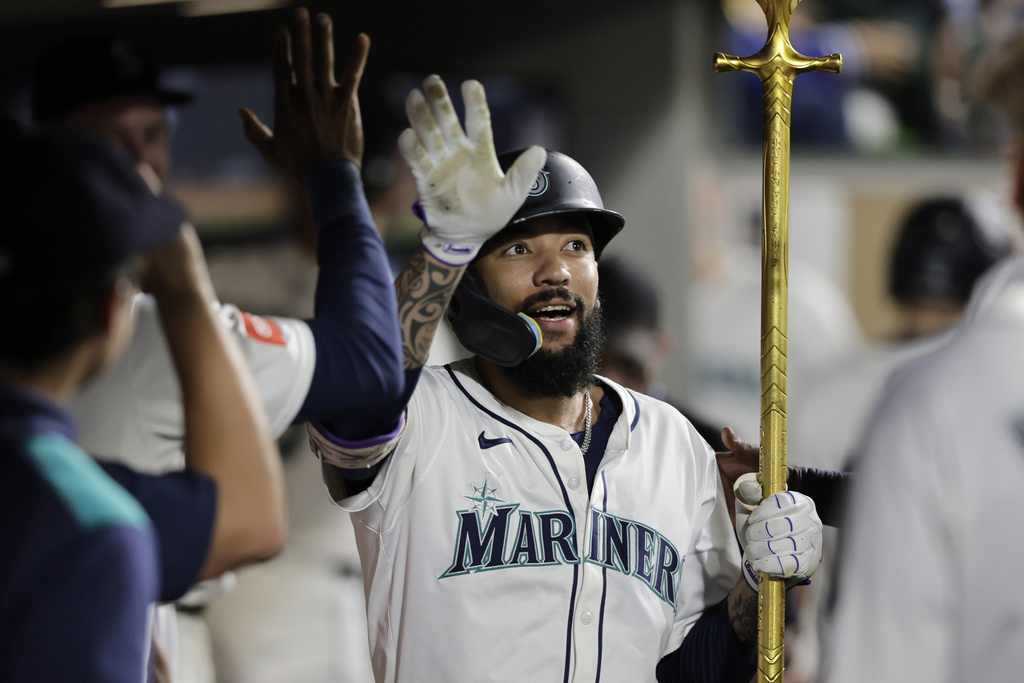 Seattle Mariners' J.P. Crawford is greeted in the dugout on his solo home run off Los Angeles Angels starting pitcher Mitch Farris during the fourth inning of a baseball game Saturday, Sept. 13, 2025, in Seattle. (AP Photo/John Froschauer)