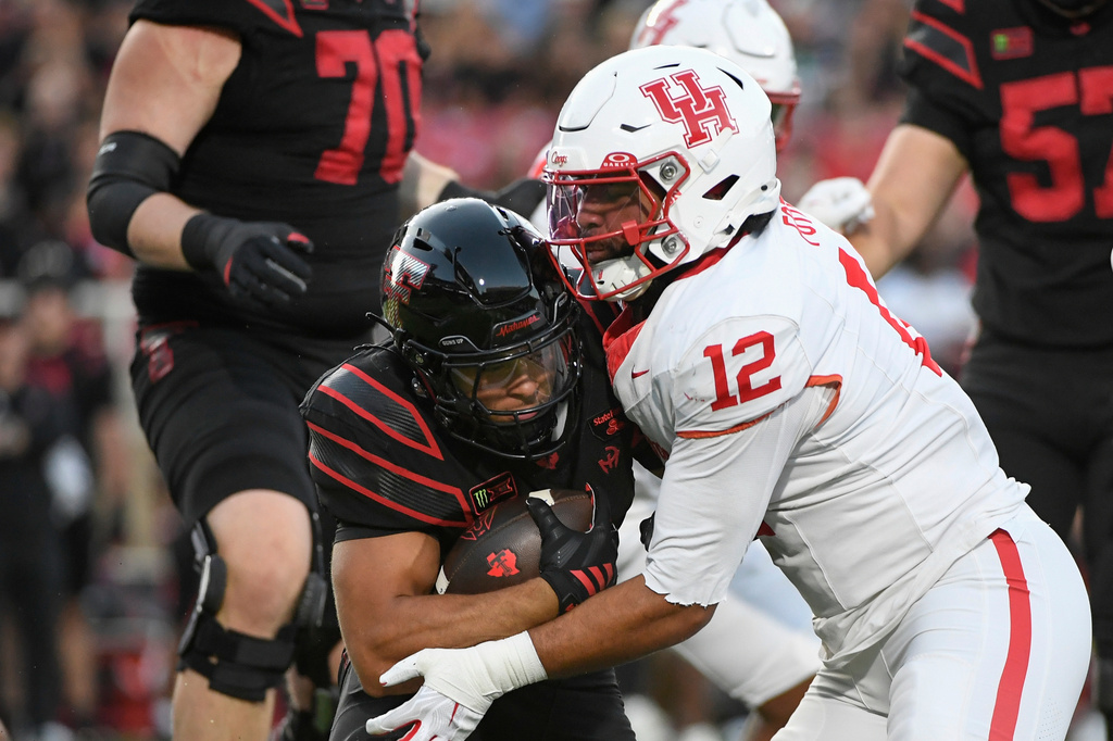 Houston linebacker Sione Fotu (12) tackles Texas Tech running back Cameron Dickey, left, during the first half of an NCAA college football game Friday, Sept. 18, 2026, in Lubbock, Texas. (AP Photo/Justin Rex)