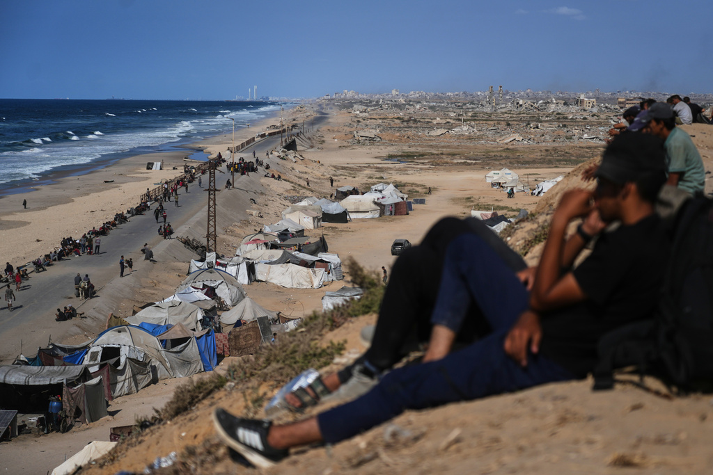 Displaced Palestinians gather on the coastal road near Wadi Gaza in the central Gaza Strip, Thursday, Oct. 9, 2025, during an attempt to return to Gaza City after the announcement that Israel and Hamas had agreed to the first phase of a peace plan to pause the fighting. (AP Photo/Abdel Kareem Hana)