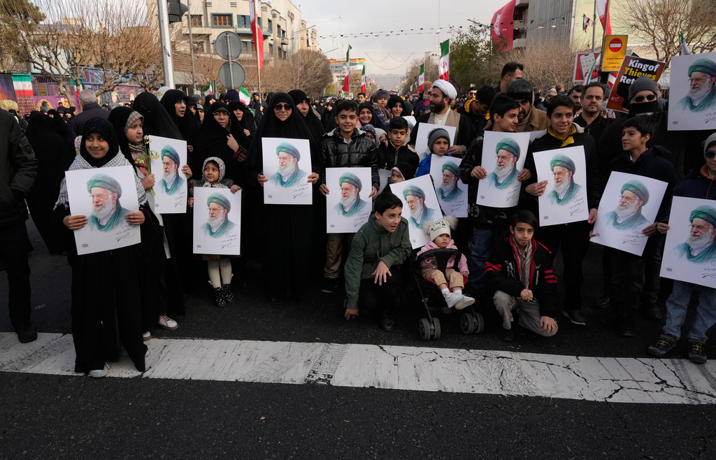 People hold posters of the Iranian Supreme Leader Ayatollah Ali Khamenei during a funeral ceremony for a group of security forces, who were killed during anti-government protests, in Tehran, Iran, Wednesday, Jan. 14, 2026. (AP Photo/Vahid Salemi)