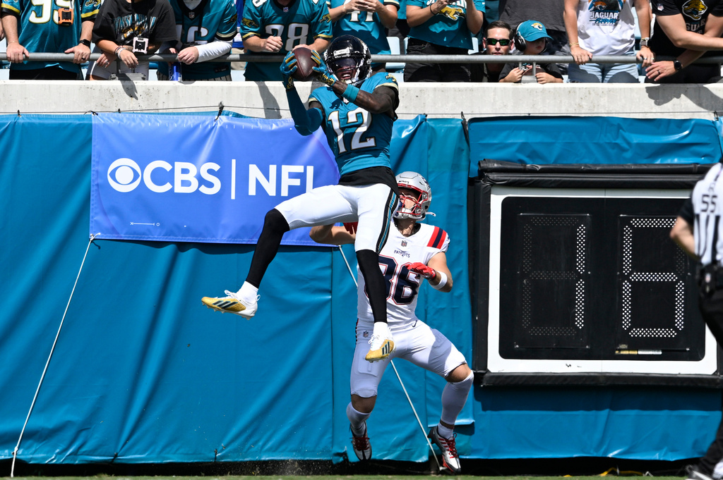 Jacksonville Jaguars wide receiver Travis Hunter (12) intercepts a pass intended for New England Patriots wide receiver Efton Chism III (86) in the first half during an NFL football game in Jacksonville, Fla., Sunday, Sept. 27, 2026. (AP Photo/Phelan M. Ebenhack)