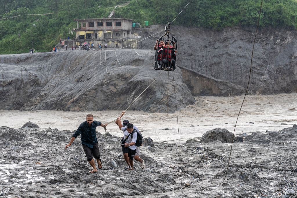 Residents pull a newly installed zipline to help people commute across the Trishuli river in the aftermath of flash floods at Bidur in Nepal's Nuwakot district, Nepal, Wednesday, Sept. 2, 2026. (AP Photo/Rajesh Kumar Singh)
