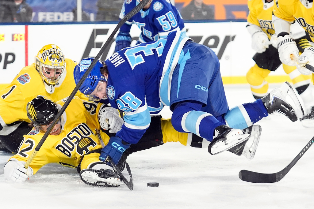 Tampa Bay Lightning left wing Brandon Hagel (38) goes down as he battles for the puck with Boston Bruins center Marat Khusnutdinov (92) and goaltender Jeremy Swayman (1) during the second period of a Stadium Series NHL hockey game Sunday, Feb. 1, 2026, in Tampa, Fla. (AP Photo/Chris O'Meara)