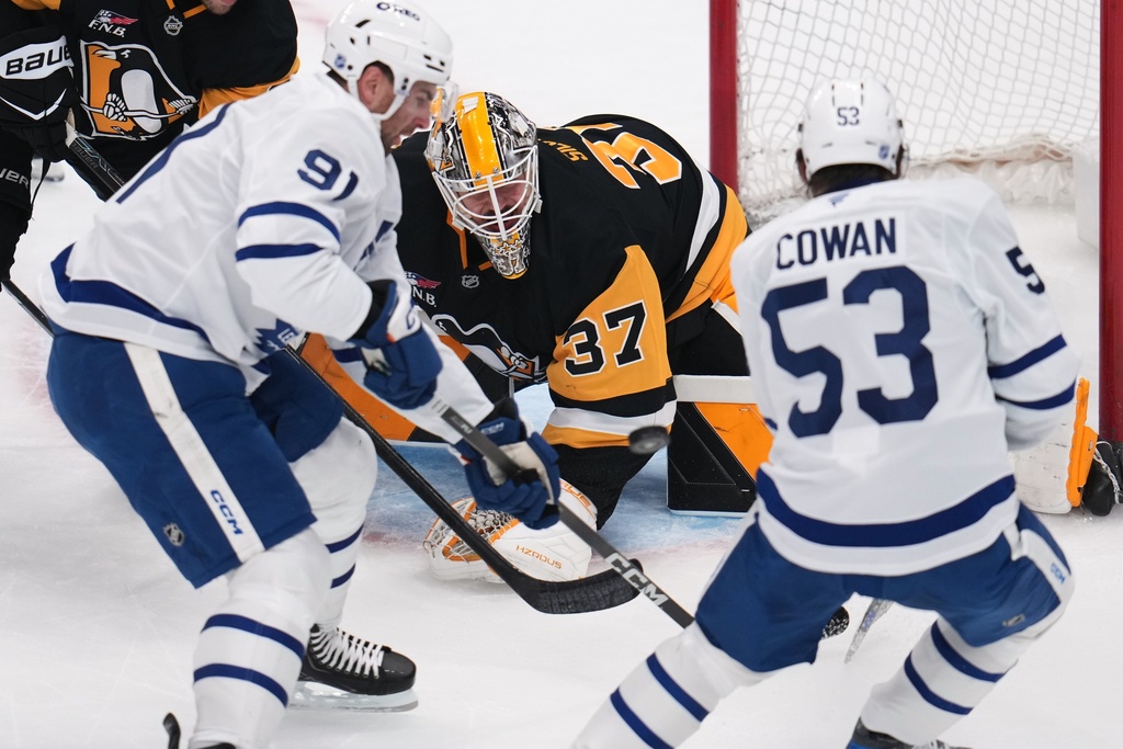 Pittsburgh Penguins goaltender Arturs Silovs (37) blocks a shot by Toronto Maple Leafs' Easton Cowan (53) with John Tavares (91) looking for the rebound during the first period of an NHL hockey game in Pittsburgh, Saturday, Nov. 29, 2025. (AP Photo/Gene J. Puskar)