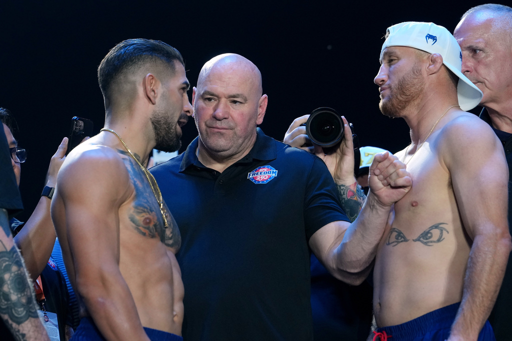 UFC commentator Joe Rogan, center, with Ilia Topuria, left, and Justin Gaethje, right, during the ceremonial UFC Freedom 250 weigh-ins on the Ellipse, Saturday, June 13, 2026, in Washington, ahead of Sunday's fight on the South Lawn of the White House. (AP Photo/Julia Demaree Nikhinson)