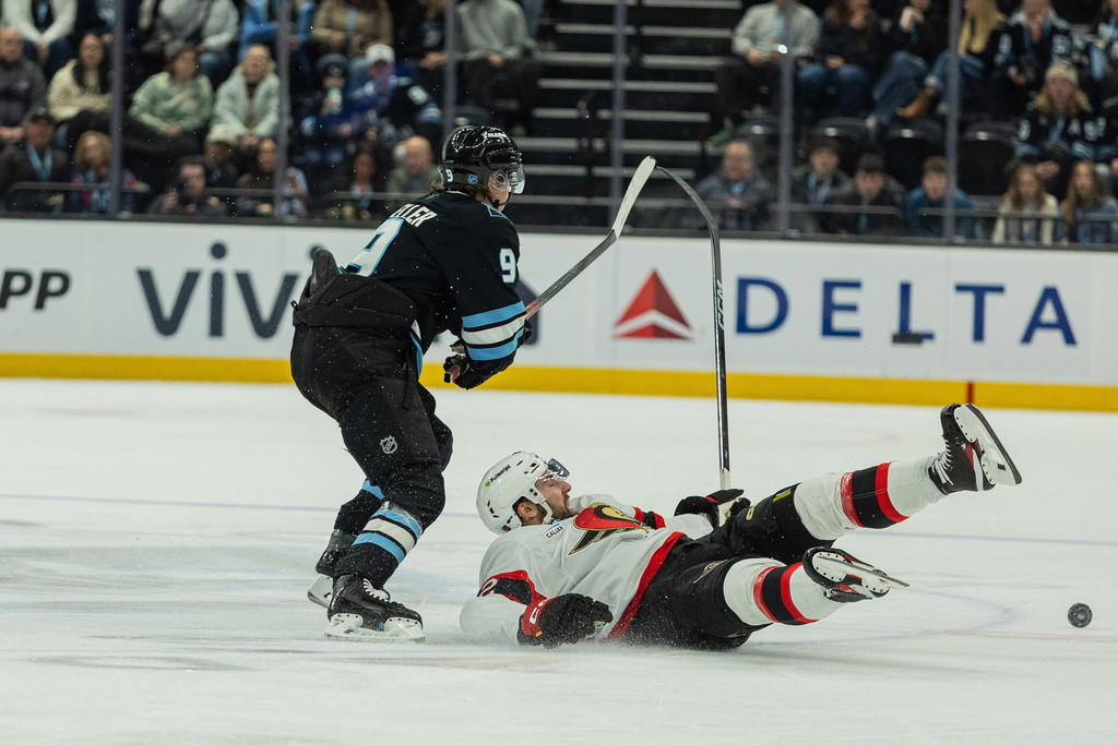 Ottawa Senators right wing Michael Amadio (22) goes down after the puck against Utah Mammoth center Clayton Keller (9) during the second period of an NHL hockey game Wednesday, Jan. 7, 2026, in Salt Lake City. (AP Photo/Melissa Majchrzak)