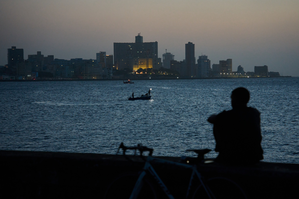A man sits on the Malecón seawall after sunset during a blackout in Havana, Cuba, Tuesday, July 14, 2026. (AP Photo/Ramon Espinosa)