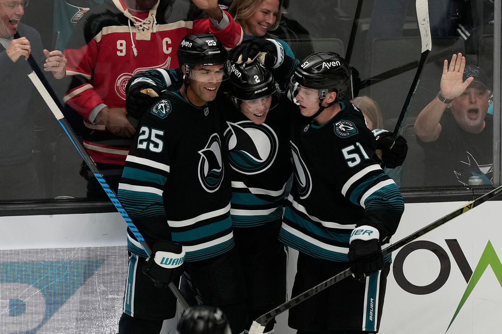 San Jose Sharks center Will Smith, middle, is congratulated by defenseman Darnell Nurse (25) and right wing Collin Graf (51) after scoring against the Vancouver Canucks during the third period of an NHL hockey game, Thursday, Oct. 29, 2026, in San Jose, Calif. (AP Photo/Jeff Chiu)