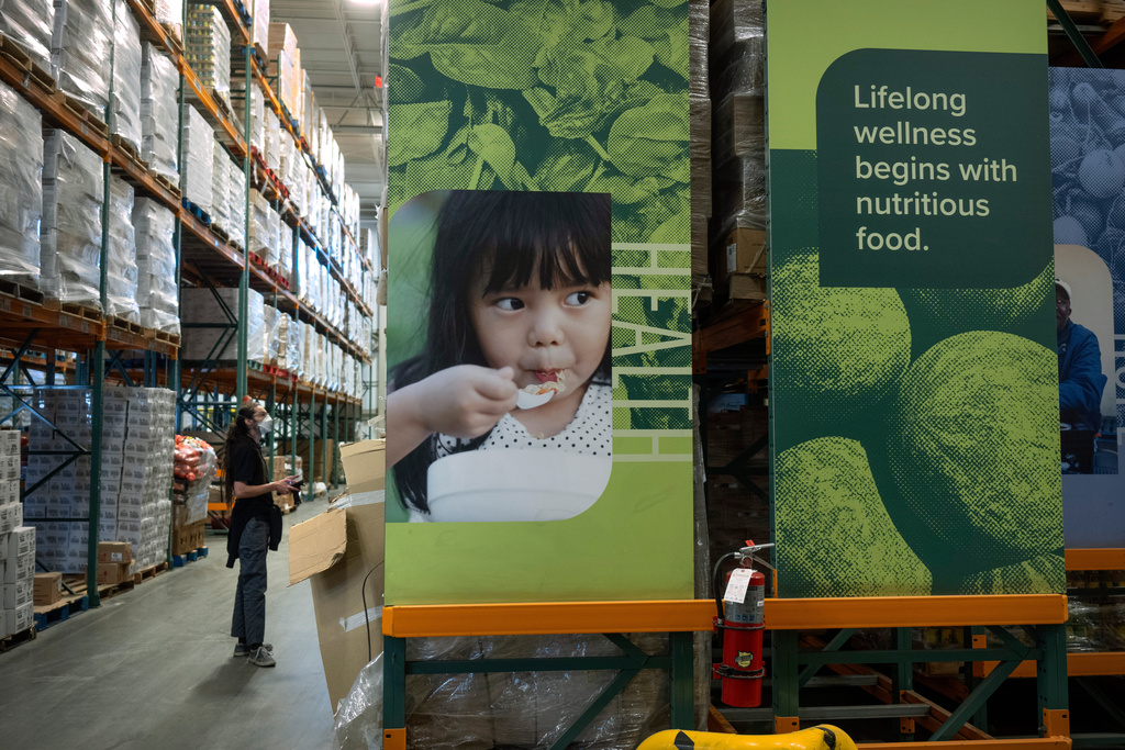An employee checks inventory at a warehouse of the Capital Area Food Bank, Thursday, Nov. 6, 2025, in Washington. (AP Photo/Mark Schiefelbein)