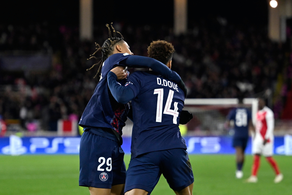 PSG's Desire Doue, right, celebrates with PSG's Bradley Barcola after scoring his side's opening goal during the first-leg of the Champions League playoff soccer match between Monaco and Paris Saint-Germain in Monaco, Tuesday, Feb. 17, 2026. (AP Photo/Philippe Magoni)