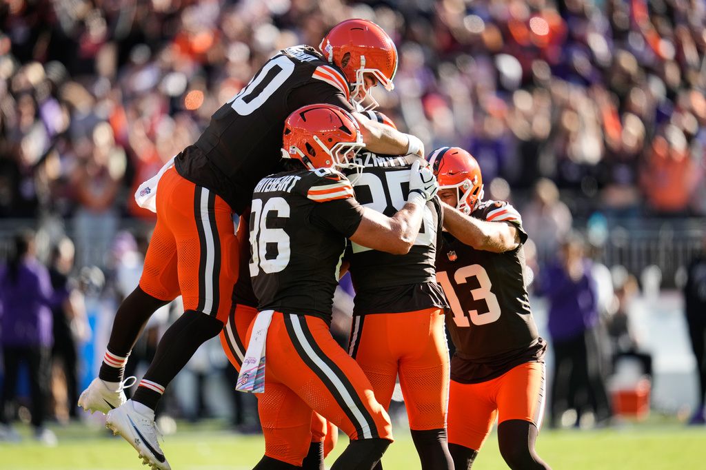 Cleveland Browns long snapper Rex Sunahara, left, and others pile on place kicker Andre Szmyt, second from right, after his game-winning field goal during the second half of an NFL football game against the Baltimore Ravens in Cleveland, Sunday, Oct. 18, 2026. (AP Photo/Sue Ogrocki)