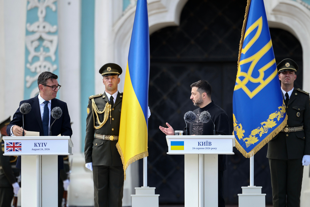 Britain's Prime Minister Andy Burnham, left, looks at Ukraine's President Volodymyr Zelensky delivering a speech during a commemorative ceremony marking Ukraine's 35th Independence Day outside St. Sofia cathedral in Kyiv, Ukraine, Monday, Aug. 24, 2026. (Henry Nicholls/Pool Photo via AP)