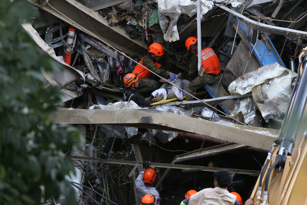 Rescuers retrieve a body inside a collapsed waste segregation facility in Binaliw, Cebu city, central Philippines on Friday, Jan. 9, 2026. (AP Photo/Jacqueline Hernandez)