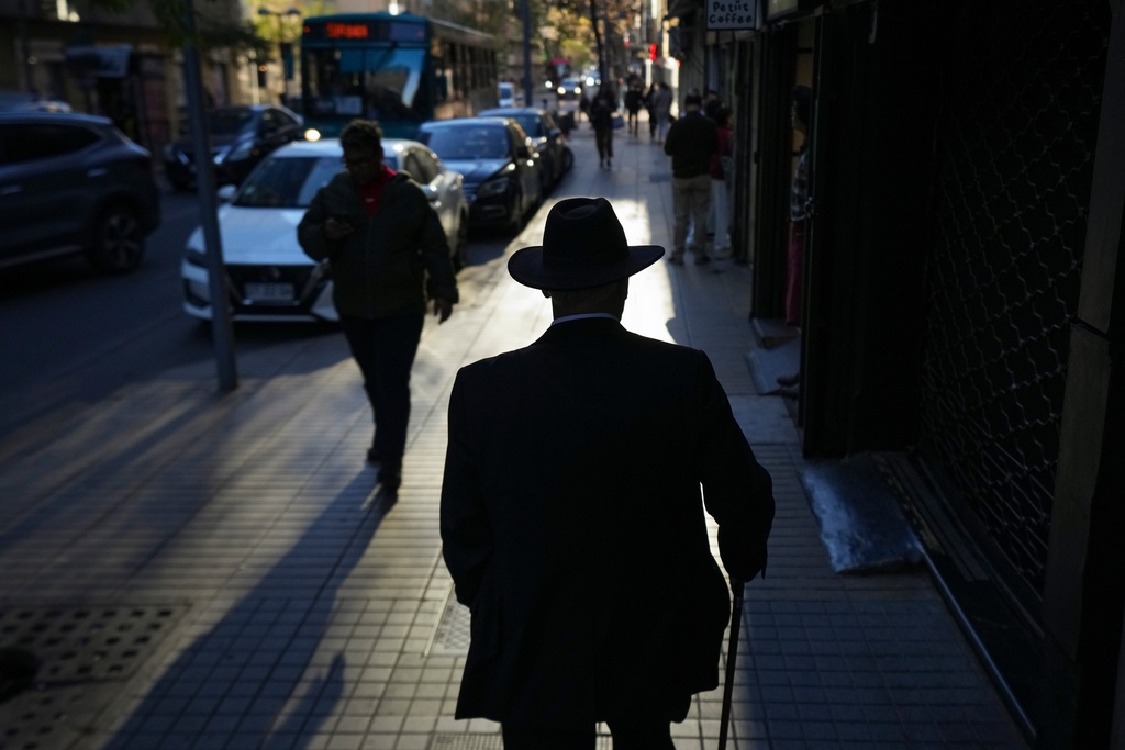 A man walks on a street in downtown Santiago, Chile, Wednesday, Oct. 1, 2025. (AP Photo/Esteban Felix)