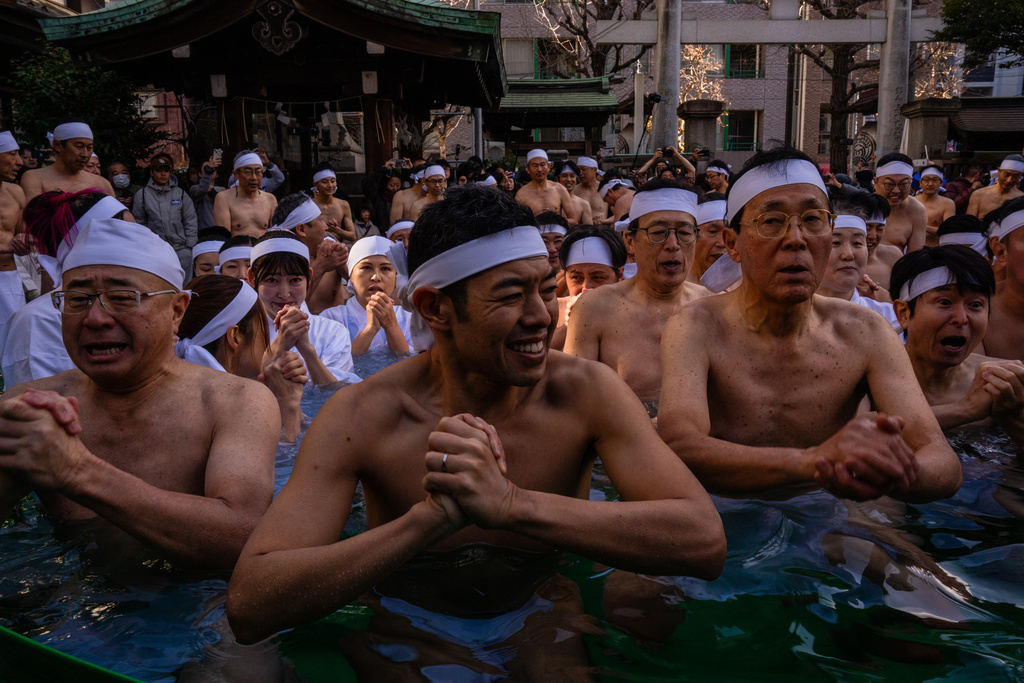 Participants bathe in ice-cold water to purify their souls and pray for good health during a New Year's ritual at Teppozu Inari Shrine in Tokyo, Sunday, Jan. 11, 2026. (AP Photo/Louise Delmotte)