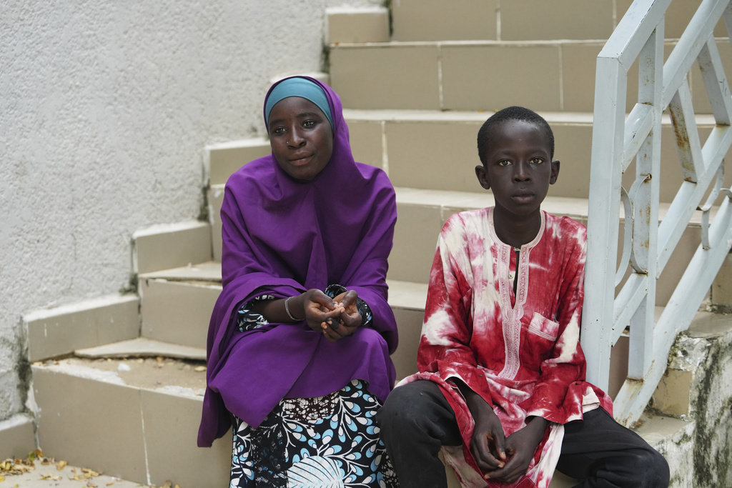 Israel Peter, who fled his village following an attack by Boko Haram Islamic extremists, right and Ramatu Usman, a student who was dropped from the school, pose for a photo, at the Future Prowess Islamic Foundation School, in Maiduguri, Nigeria, Thursday, July 24, 2025. (AP Photo/Sunday Alamba)