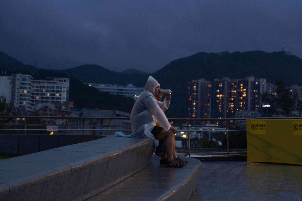 An man drinks a beer as he watches waves crashing on a beach in the aftermath of Super Typhoon Ragasa in Shenzhen in southern China's Guangdong province on Wednesday, Sept. 24, 2025. (AP Photo/Ng Han Guan)