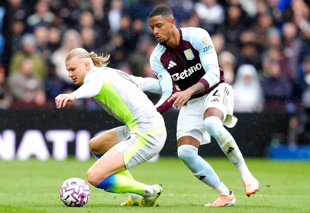 Manchester City's Erling Haaland (left) and Aston Villa's Ezri Konsa battle for the ball during the English Premier League match between Aston Villa and Manchester City, in Birmingham, England, Sunday Oct. 26, 2025. (Nick Potts/PA via AP)