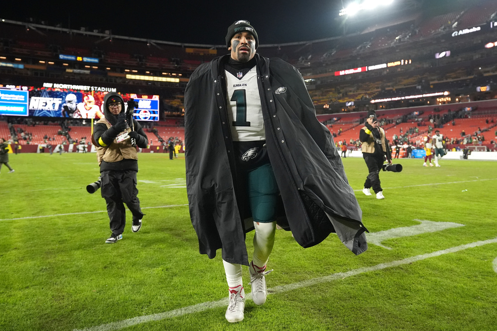 Philadelphia Eagles quarterback Jalen Hurts, center, leaves the field after a win over the Washington Commanders in an NFL football game, Saturday, Dec. 20, 2025, in Landover, Md. (AP Photo/Stephanie Scarbrough)