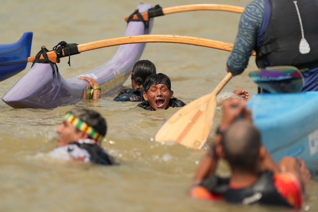 Indigenous peoples cool off as they participate in a People's Summit event on Guajara Bay during the COP30 U.N. Climate Summit, Wednesday, Nov. 12, 2025, in Belem, Brazil. (AP Photo/Joshua A. Bickel)
