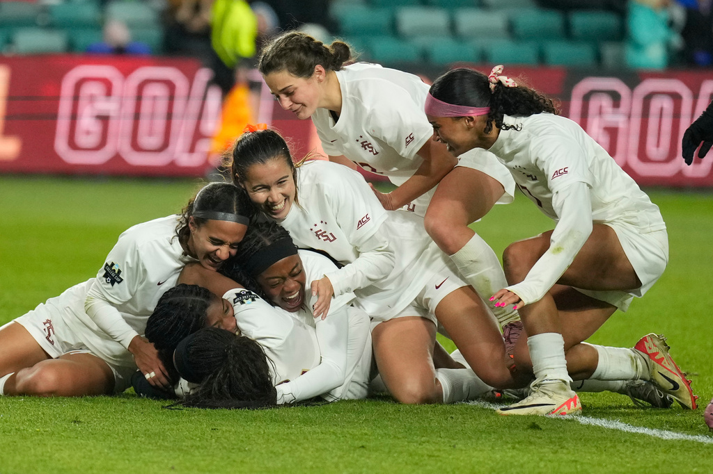 Florida State players congratulate Wrianna Hudson on her goal during the second half of the NCAA college soccer tournament final against Stanford Monday, Dec. 8, 2025, in Kansas City, Mo. (AP Photo/Charlie Riedel)
