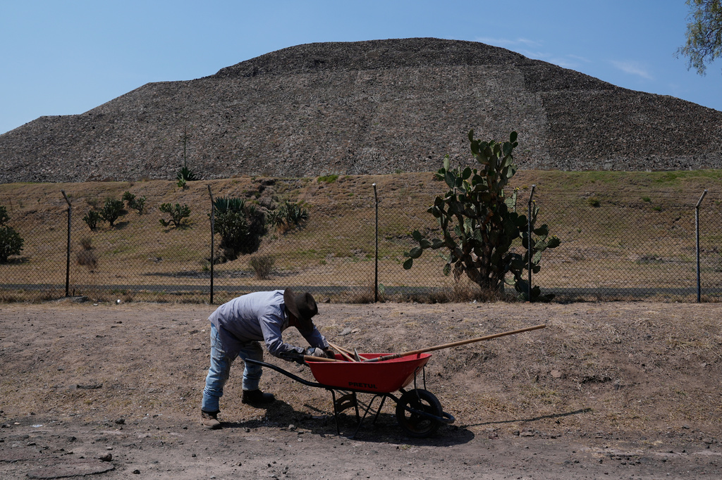 A worker pushes a wheelbarrow at the Teotihuacan pyramids, which remained closed a day after a gunman opened fire on tourists at the archaeological site on the outskirts of Mexico City, Tuesday, April 21, 2026. (AP Photo/Marco Ugarte)