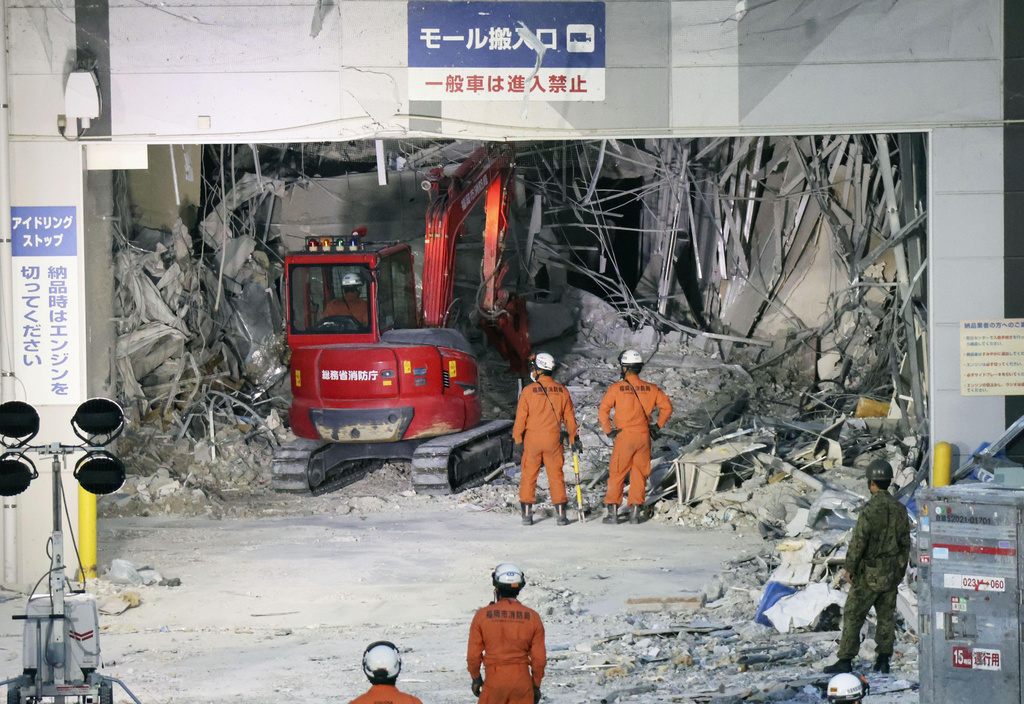 Heavy machinery removes debris at AEON Mall, which was damaged by an explosion following an earthquake, in Kashima, Kumamoto Prefecture, southern Japan, Friday, July 31, 2026. (Kyodo News via AP)