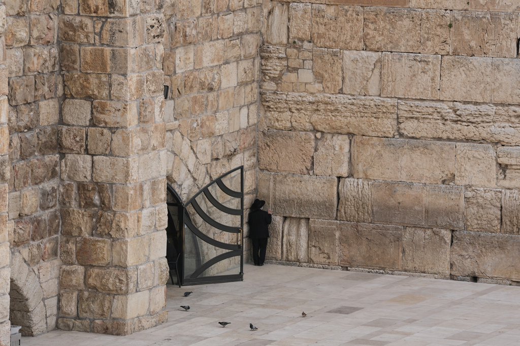 A Jewish man prays at the nearly empty Western Wall plaza in Jerusalem's Old City Wednesday, March 25, 2026, as the area remains closed to visitors amid the war with Iran. (AP Photo/Mahmoud Illean)